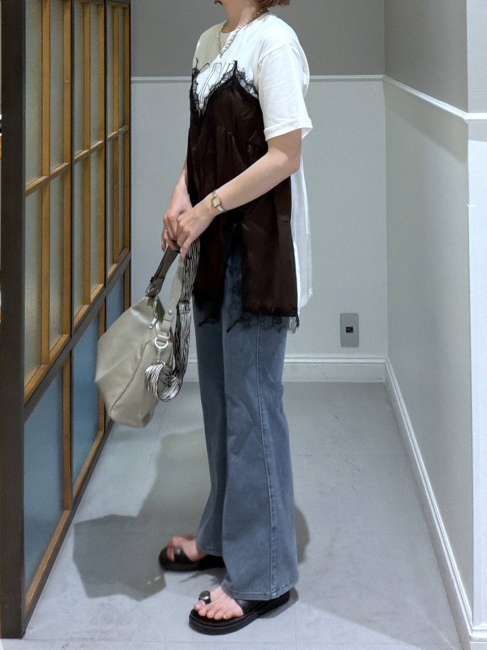 ブラック系のサンダル、ベージュ系のショルダーバッグ、ブラウン系のTシャツ/カットソーを着用したレディースの夏コーディネートの2枚目の写真