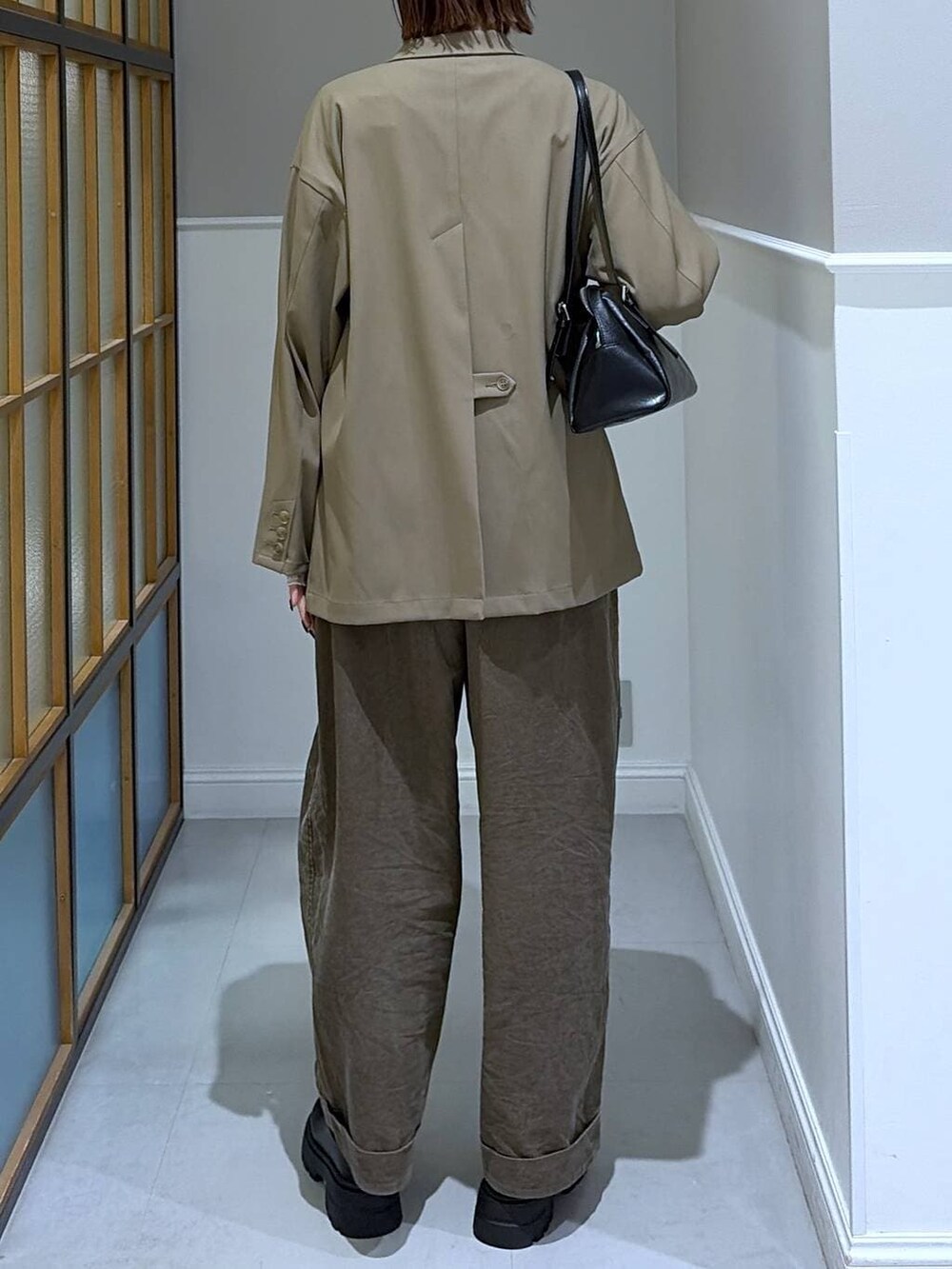 ブラック系のボストンバッグ、ブラウン系のその他パンツ、ブラウン系のテーラードジャケットを着用したレディースの冬コーディネートの3枚目の写真