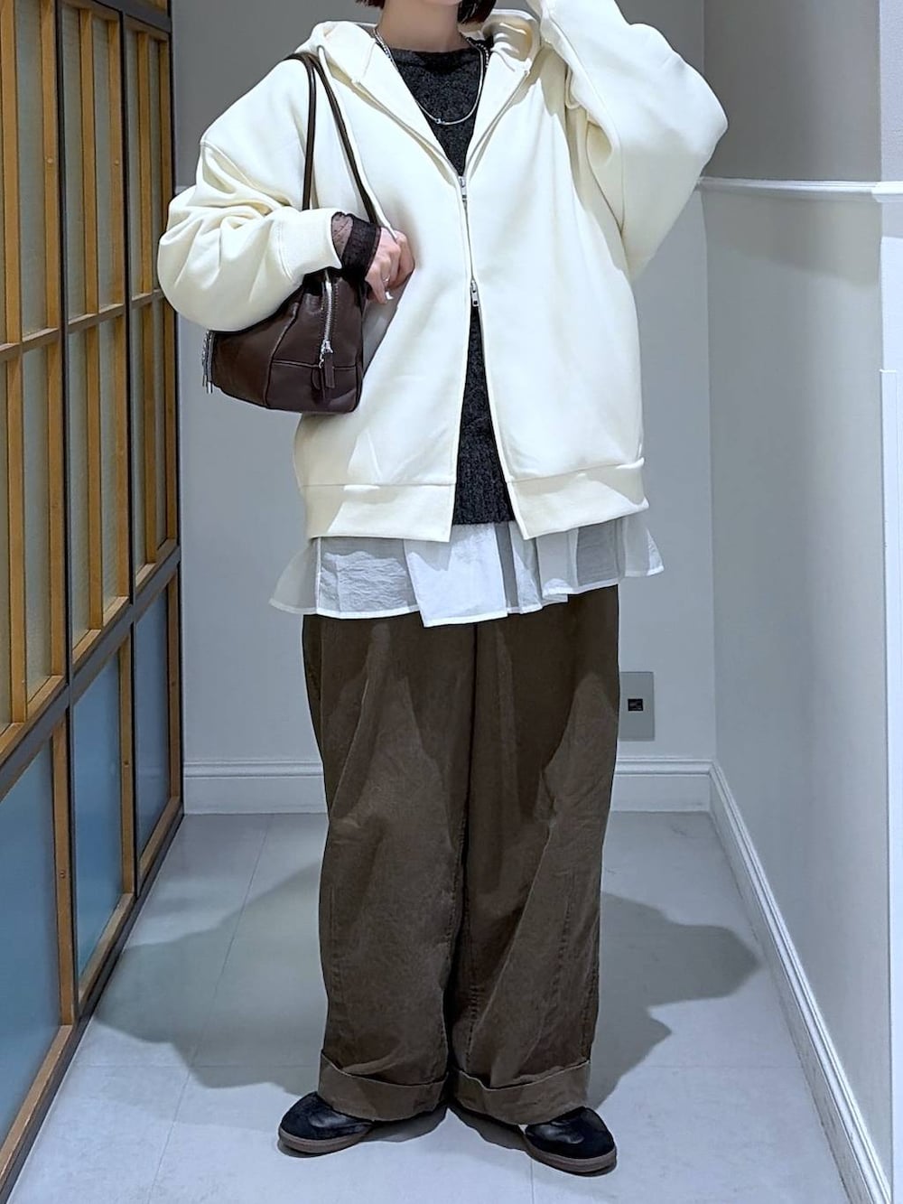 ホワイト系のTシャツ/カットソー、ホワイト系のパーカー、グレー系のニット/セーターを着用したレディースの冬コーディネートの2枚目の写真