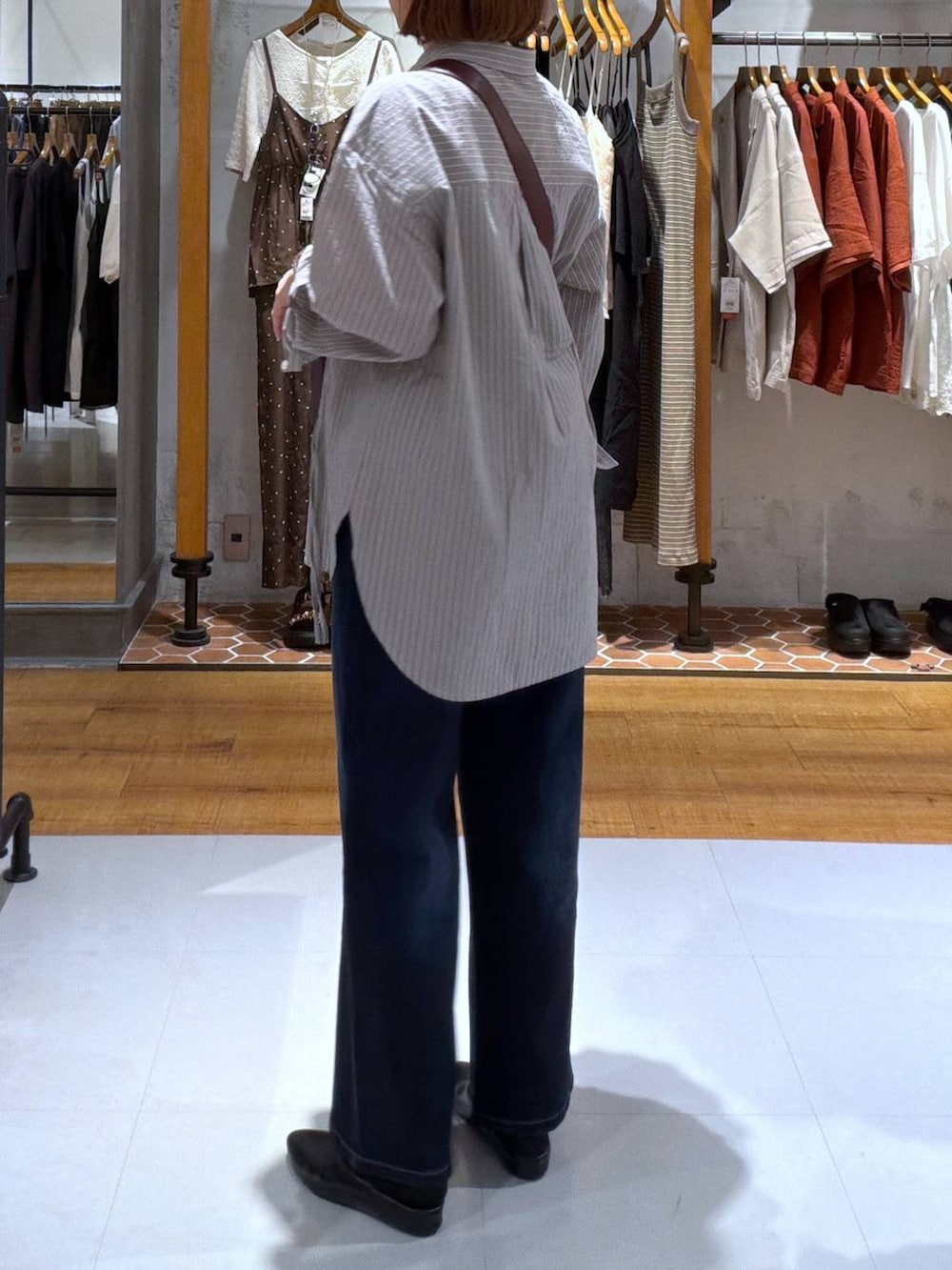 ブラウン系のシャツ/ブラウス、ブラック系のその他シューズ、レッド系のショルダーバッグを着用したレディースの夏コーディネートの2枚目の写真