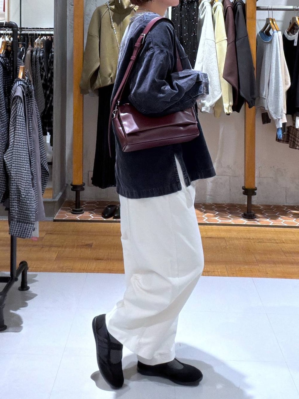 ブラック系のパンプス、ブルー系のカーディガン/ボレロ、ホワイト系のTシャツ/カットソーを着用したレディースの秋コーディネートの2枚目の写真
