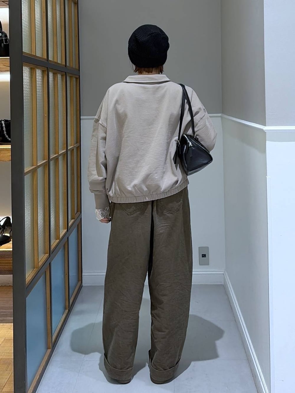 ブラック系のボストンバッグ、ブラウン系のその他パンツ、ホワイト系のTシャツ/カットソーを着用したレディースの冬コーディネートの3枚目の写真