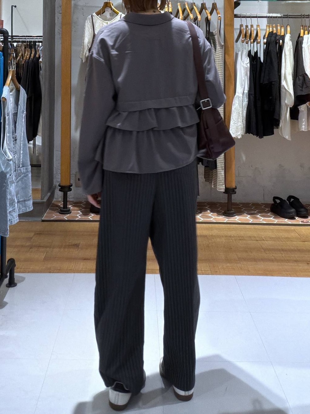 グレー系のテーラードジャケット、ホワイト系のその他パンツ、レッド系のショルダーバッグを着用したレディースの夏コーディネートの2枚目の写真