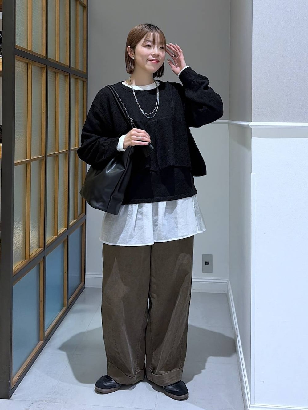 ホワイト系のTシャツ/カットソー、ブラック系のトートバッグ、ブラウン系のその他パンツを着用したレディースの冬コーディネートの2枚目の写真