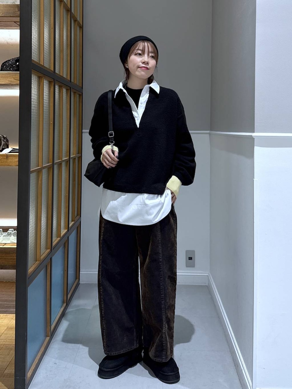 ブラック系のニット/セーター、ブラック系のショルダーバッグ、ブラック系のその他シューズを着用したレディースの冬コーディネートの2枚目の写真