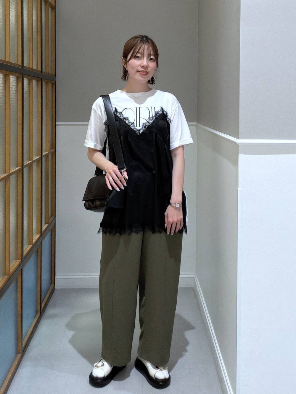 ブラック系のショルダーバッグ、グリーン系のその他パンツ、ホワイト系のサンダルを着用したレディースの春コーディネートの2枚目の写真