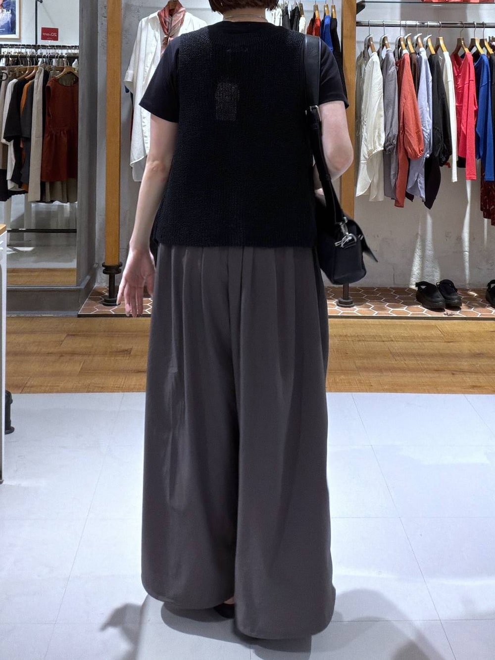 ブラック系のショルダーバッグ、ブラック系のサンダル、ブラック系のTシャツ/カットソーを着用したレディースの夏コーディネートの2枚目の写真