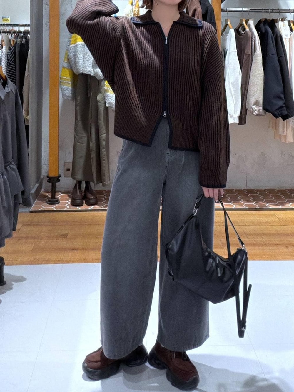 グレー系のデニムパンツ、ブラウン系のスニーカー、ブルー系のカーディガン/ボレロを着用したレディースの秋コーディネートの2枚目の写真