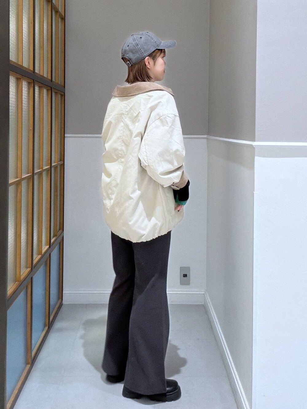 グレー系のその他パンツ、ベージュ系のステンカラーコート、ブラック系のボストンバッグを着用したレディースの冬コーディネートの3枚目の写真