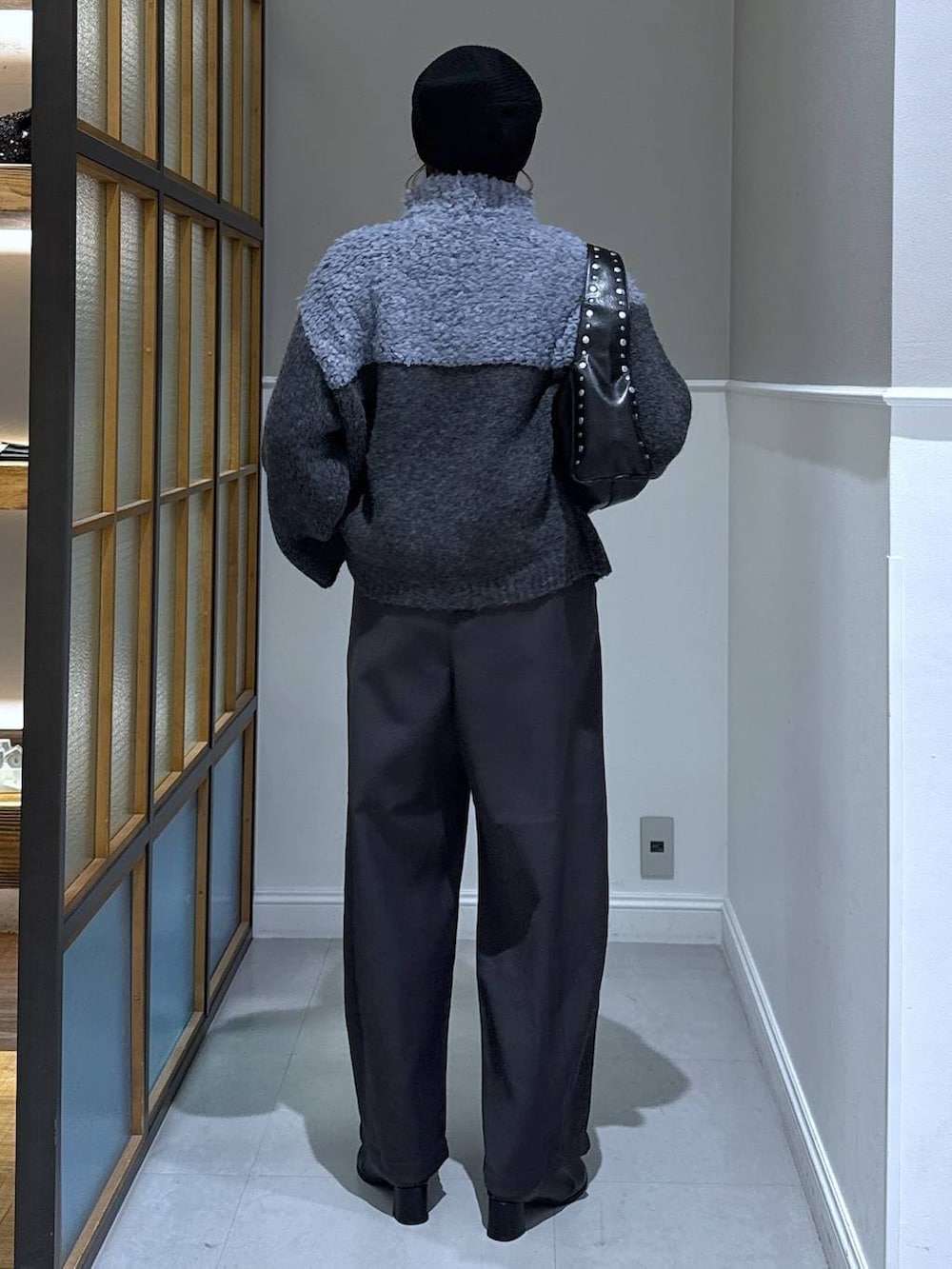 ブラック系のニット/セーター、グレー系のその他パンツ、ブラック系のブーツを着用したレディースの冬コーディネートの2枚目の写真