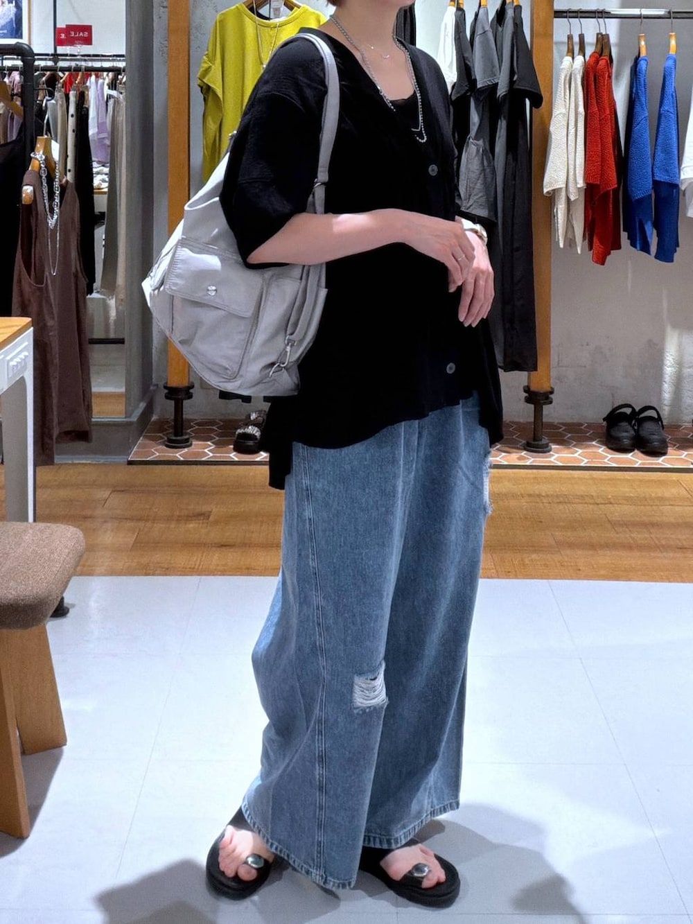 ブラック系のカーディガン/ボレロ、グレー系のショルダーバッグ、ブルー系のデニムパンツを着用したレディースの夏コーディネートの2枚目の写真
