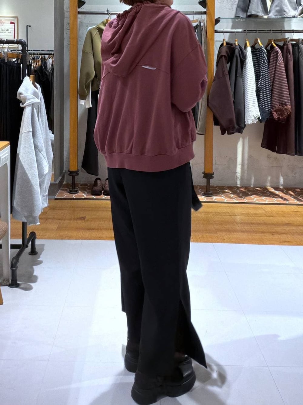 ブラック系のその他パンツ、レッド系のパーカー、ブラック系のブーツを着用したレディースの秋コーディネートの2枚目の写真