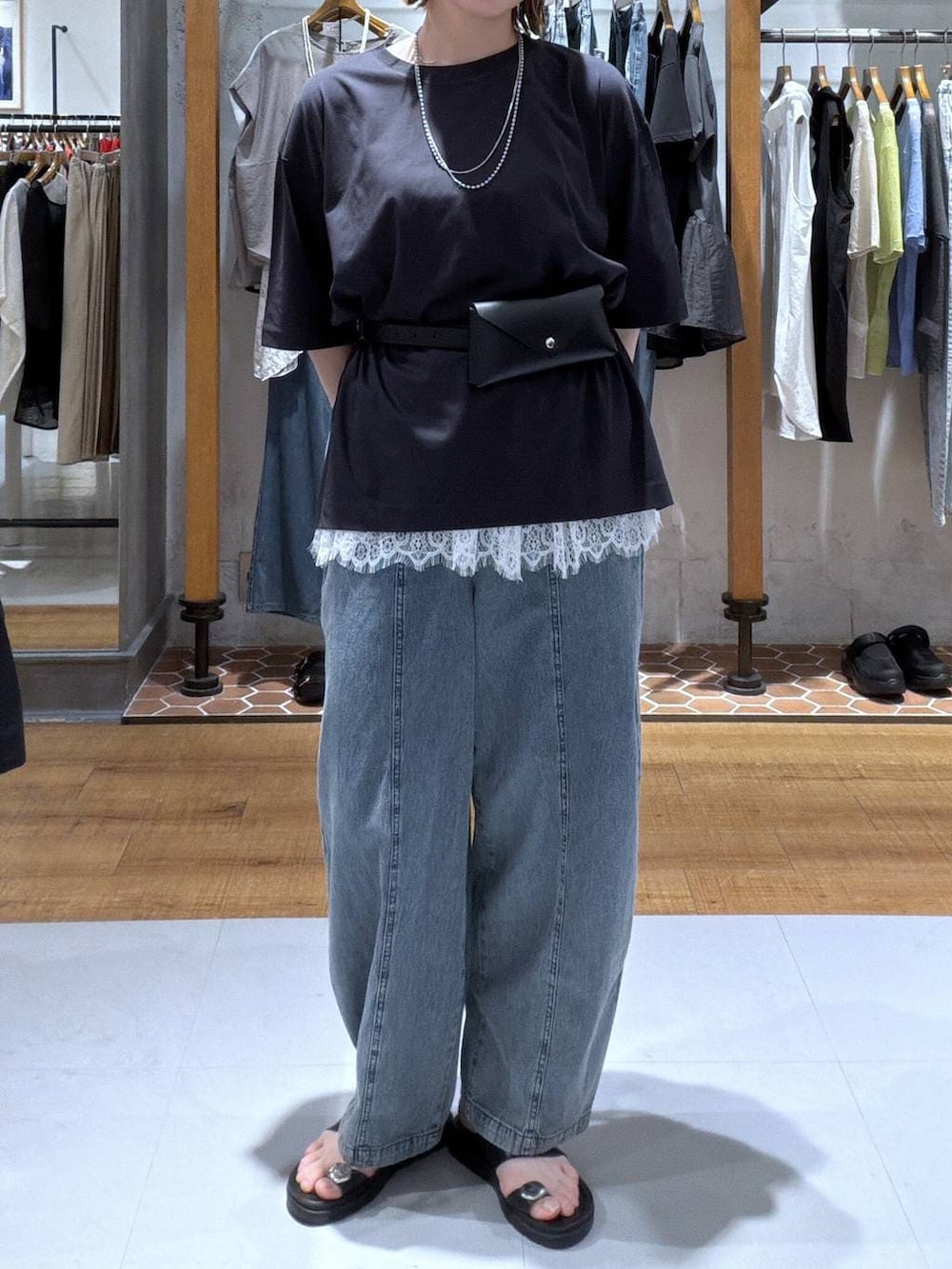 ブラック系のTシャツ/カットソー、ブラック系のサンダル、ホワイト系のキャミソールを着用したレディースの夏コーディネートの2枚目の写真