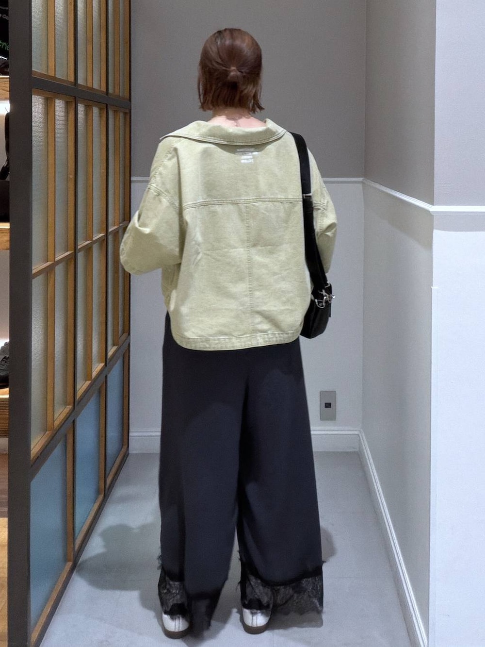 ブラック系のショルダーバッグ、グリーン系のシャツ/ブラウス、グレー系のサロペット/オーバーオールを着用したレディースの春コーディネートの2枚目の写真