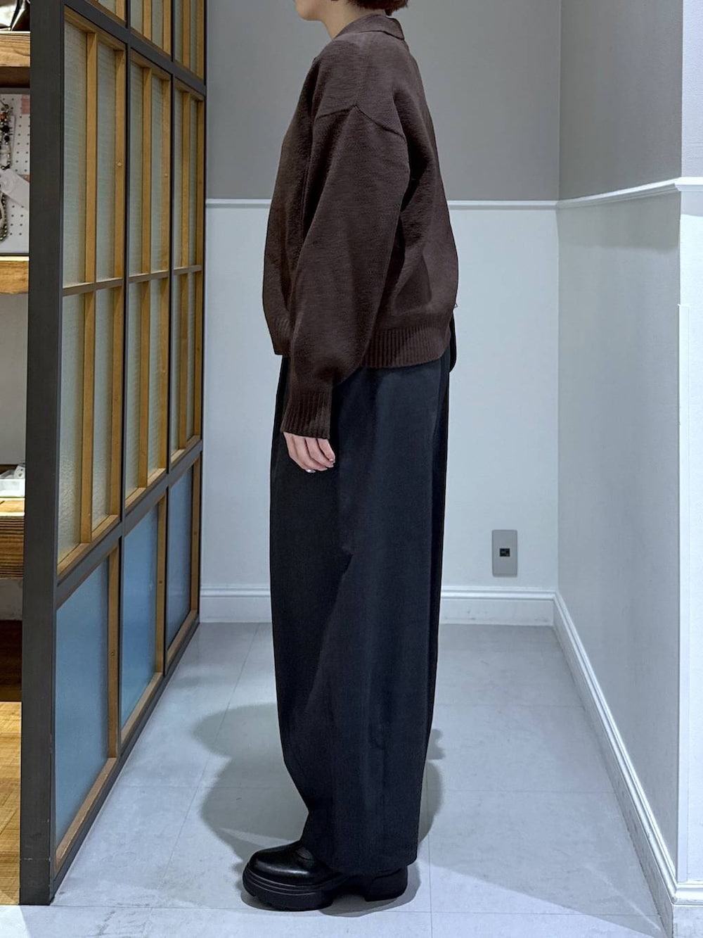 グレー系のその他パンツ、ブラウン系のニット/セーター、ブラック系のブーツを着用したレディースの秋コーディネートの2枚目の写真