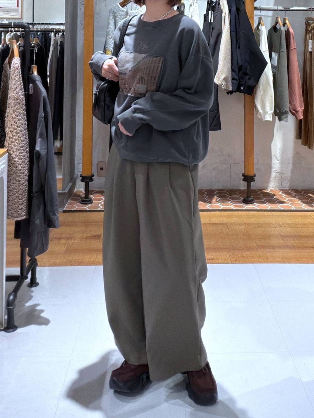 ブラック系のボストンバッグ、グリーン系のその他パンツ、ブラウン系のスニーカーを着用したレディースの秋コーディネートの2枚目の写真