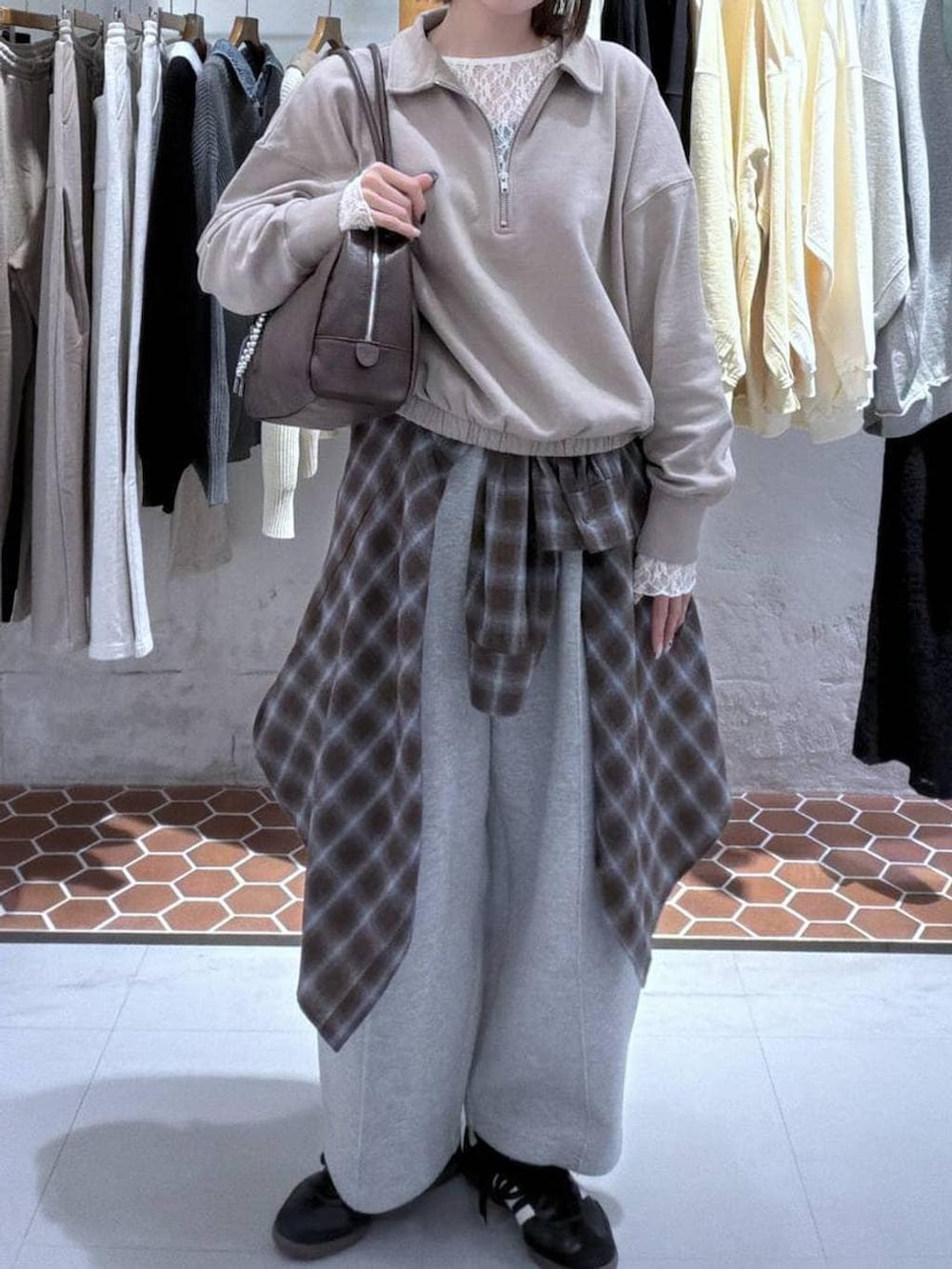 グレー系のスウェットパンツ、ブラウン系のボストンバッグ、ベージュ系のTシャツ/カットソーを着用したレディースの冬コーディネートの2枚目の写真