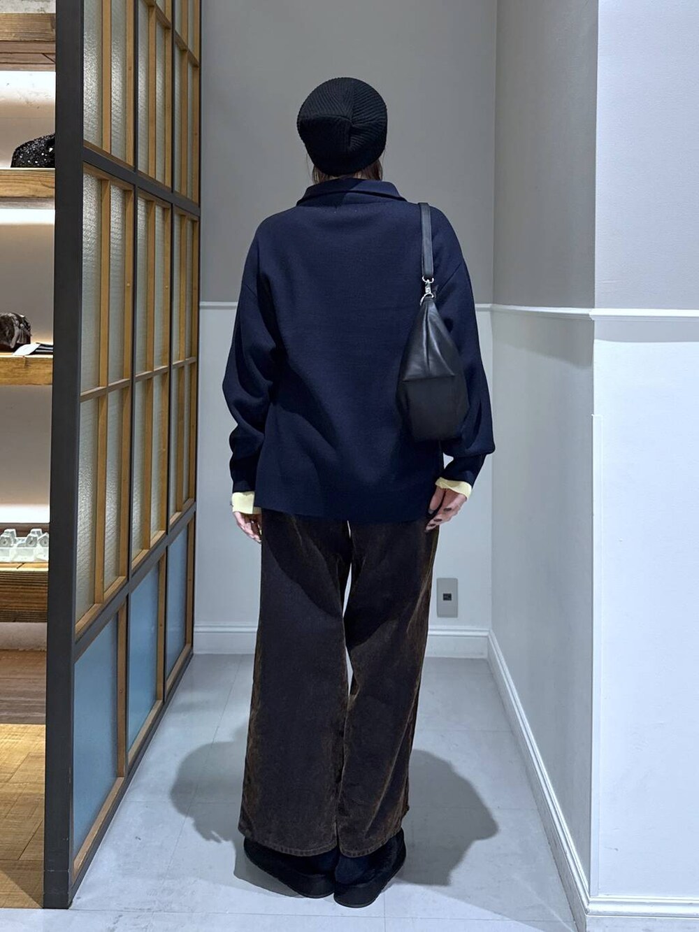 ブラック系のニット/セーター、ブラック系のショルダーバッグ、ブラック系のその他シューズを着用したレディースの冬コーディネートの4枚目の写真