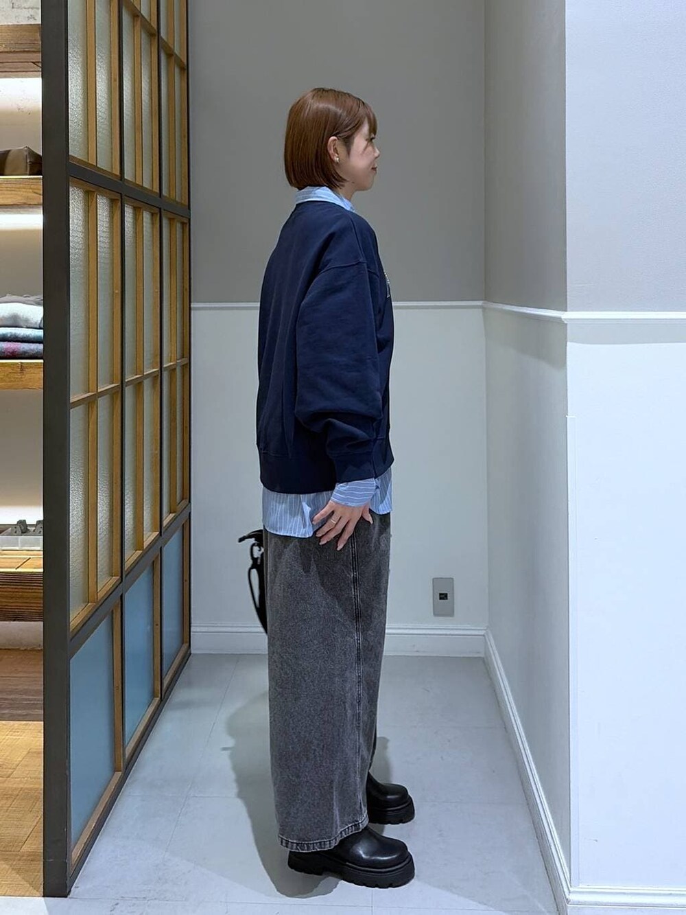 グレー系のデニムパンツ、ブルー系のシャツ/ブラウス、ブラック系のトートバッグを着用したレディースの冬コーディネートの3枚目の写真