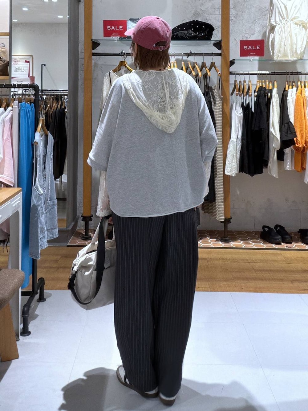 ホワイト系のシャツ/ブラウス、ホワイト系のその他パンツ、ホワイト系のトートバッグを着用したレディースの夏コーディネートの2枚目の写真