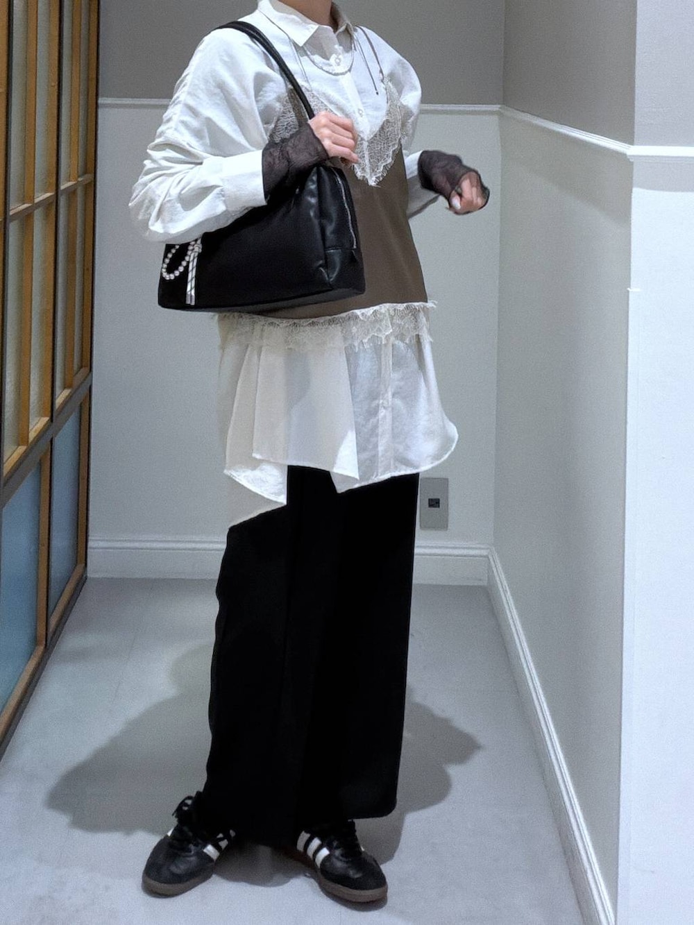 ベージュ系のシャツ/ブラウス、ブラック系のボストンバッグ、グレー系のTシャツ/カットソーを着用したレディースの春コーディネートの2枚目の写真