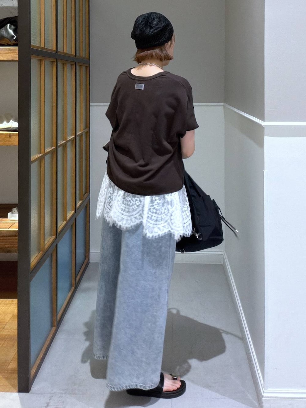 ブルー系のデニムパンツ、ブラック系のサンダル、ブラック系のバックパック/リュックを着用したレディースの春コーディネートの2枚目の写真