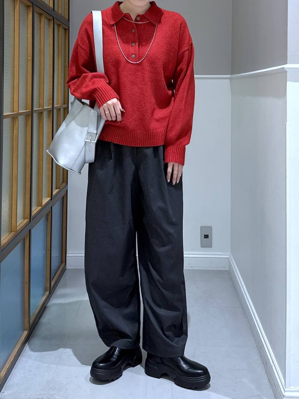 グレー系のその他パンツ、レッド系のニット/セーター、シルバー系のショルダーバッグを着用したレディースの秋コーディネートの2枚目の写真