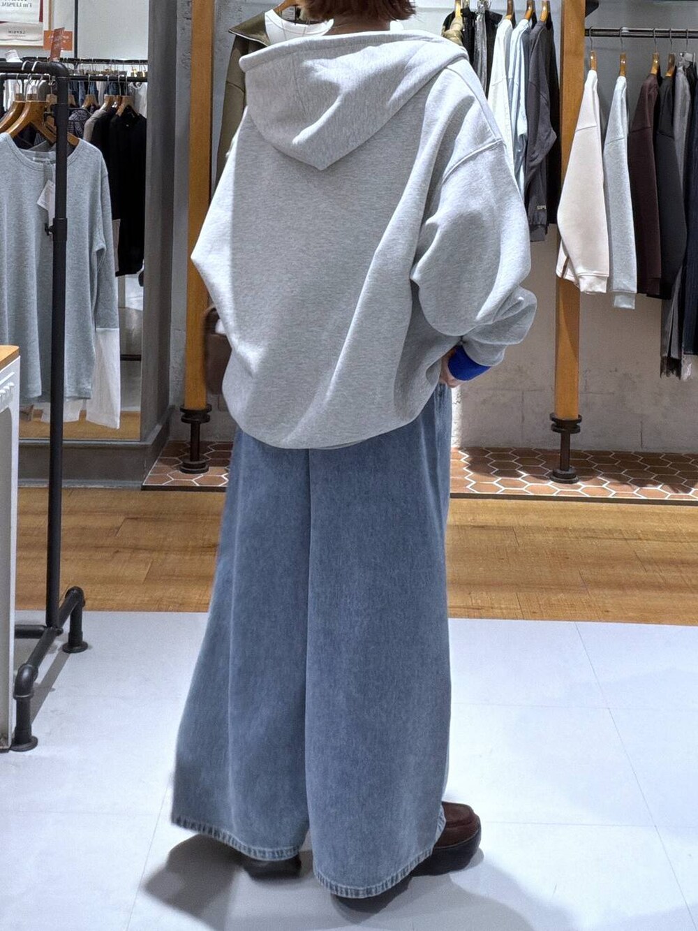 ベージュ系のニット/セーター、ブラウン系のボストンバッグ、ブラウン系のスニーカーを着用したレディースの秋コーディネートの2枚目の写真