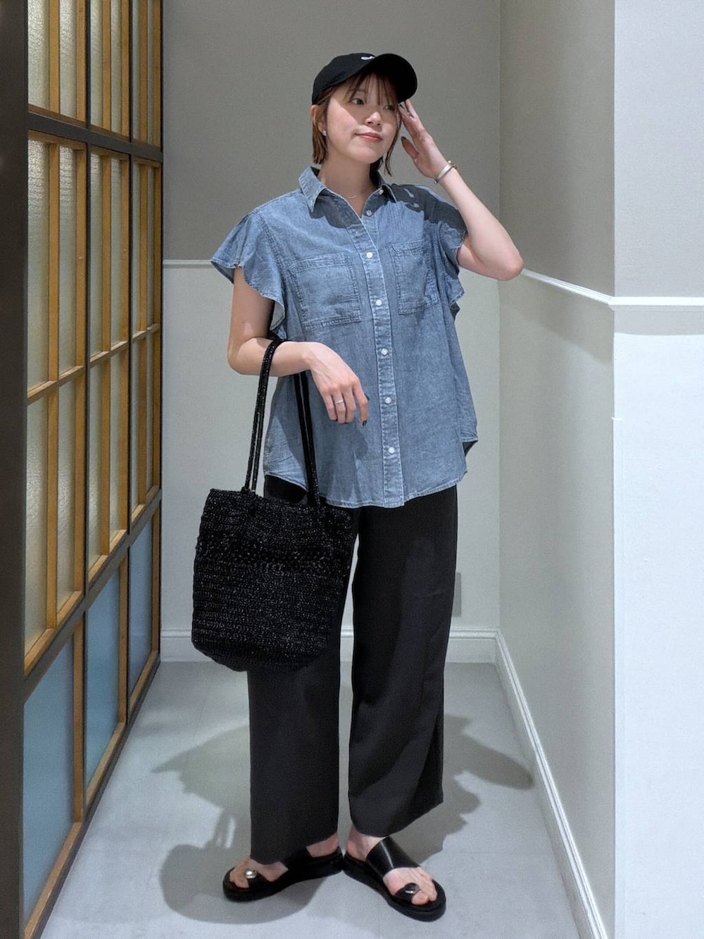 グレー系のその他パンツ、ブラック系のサンダル、ブラック系のショルダーバッグを着用したレディースの春コーディネートの2枚目の写真