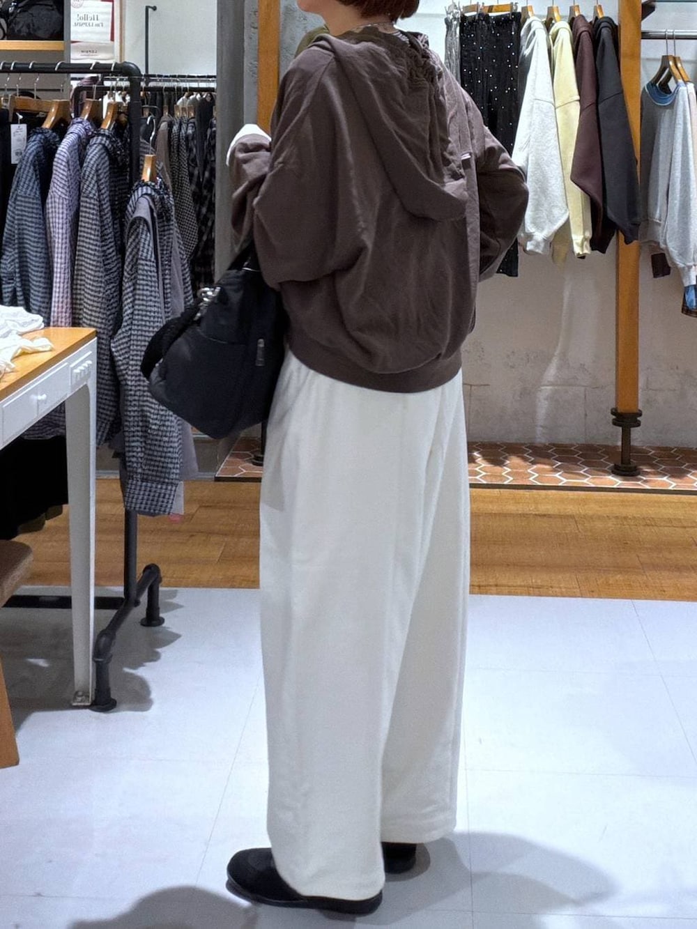 ブラック系のパンプス、ブラウン系のパーカー、ホワイト系のTシャツ/カットソーを着用したレディースの秋コーディネートの2枚目の写真