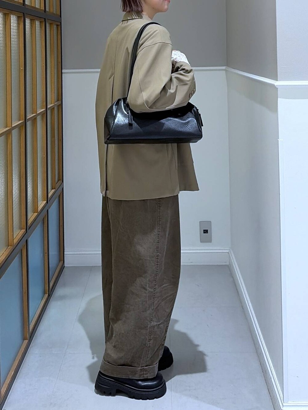 ブラック系のボストンバッグ、ブラウン系のその他パンツ、ブラウン系のテーラードジャケットを着用したレディースの冬コーディネートの2枚目の写真