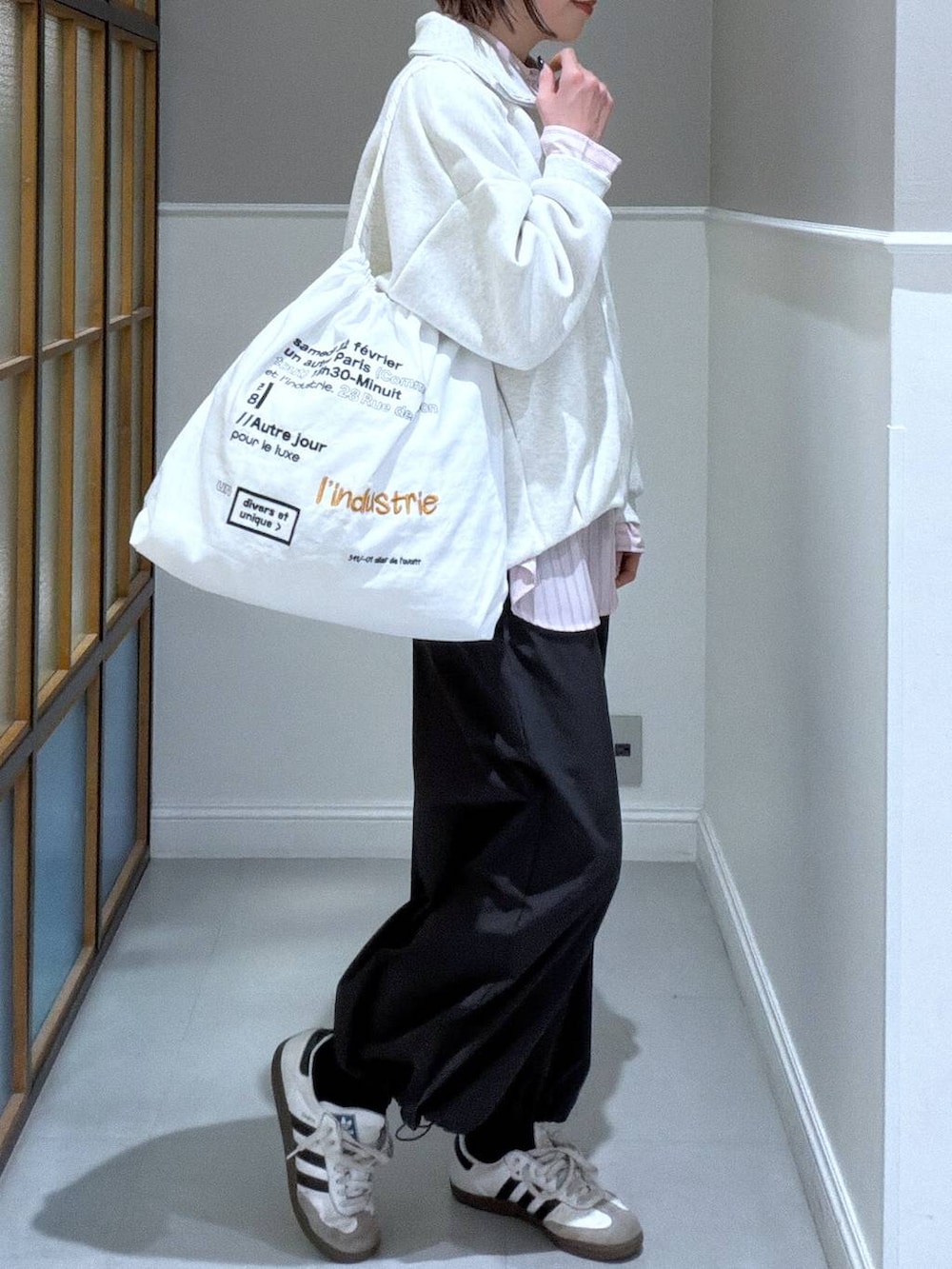 グレー系のその他パンツ、ピンク系のシャツ/ブラウス、ホワイト系のトートバッグを着用したレディースの冬コーディネートの3枚目の写真