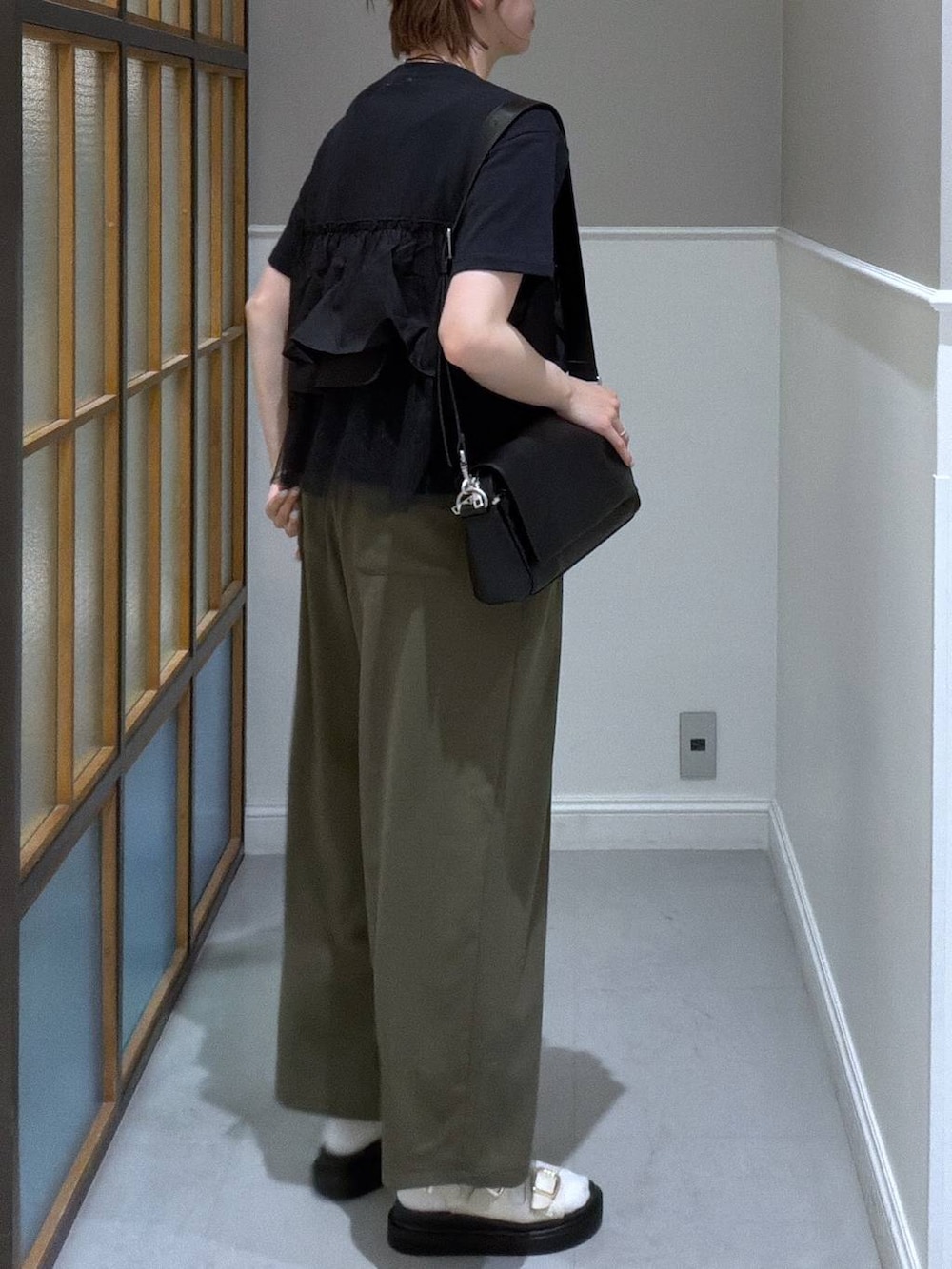 ブラック系のショルダーバッグ、グリーン系のその他パンツ、ホワイト系のサンダルを着用したレディースの春コーディネートの2枚目の写真
