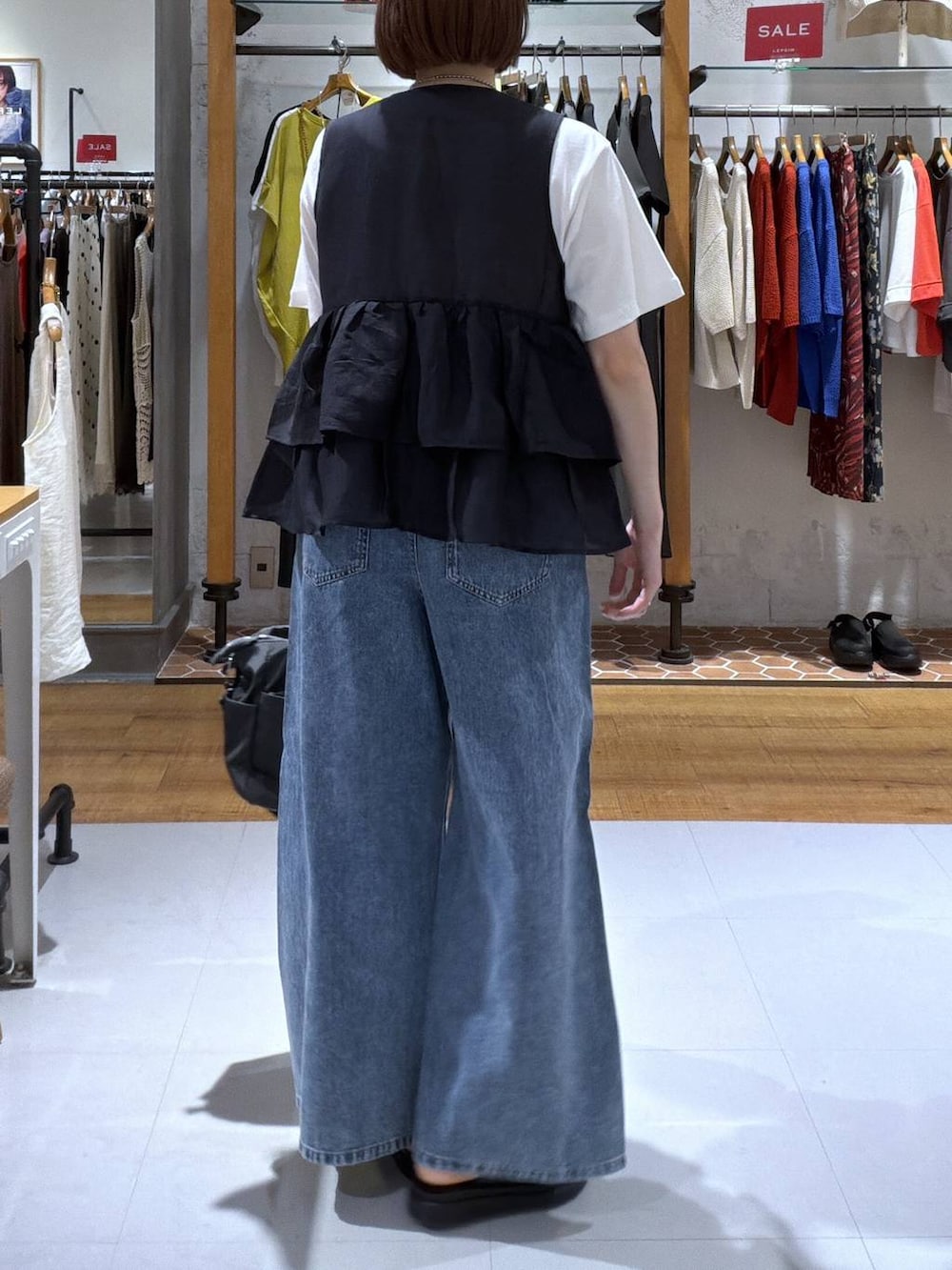 ホワイト系のTシャツ/カットソー、ブルー系のデニムパンツ、グレー系のトートバッグを着用したレディースの夏コーディネートの2枚目の写真