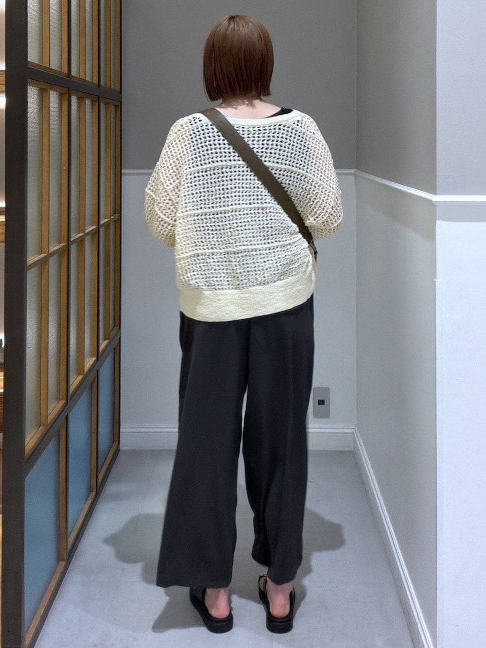 ブラウン系のショルダーバッグ、グレー系のその他パンツ、ブラック系のサンダルを着用したレディースの春コーディネートの2枚目の写真