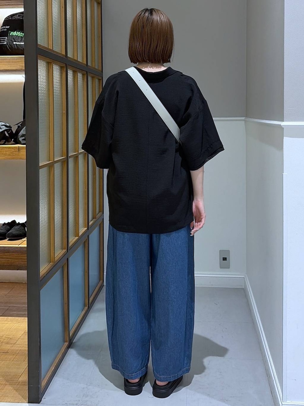 グレー系のショルダーバッグ、ブラック系のサンダル、ブラック系のテーラードジャケットを着用したレディースの春コーディネートの3枚目の写真