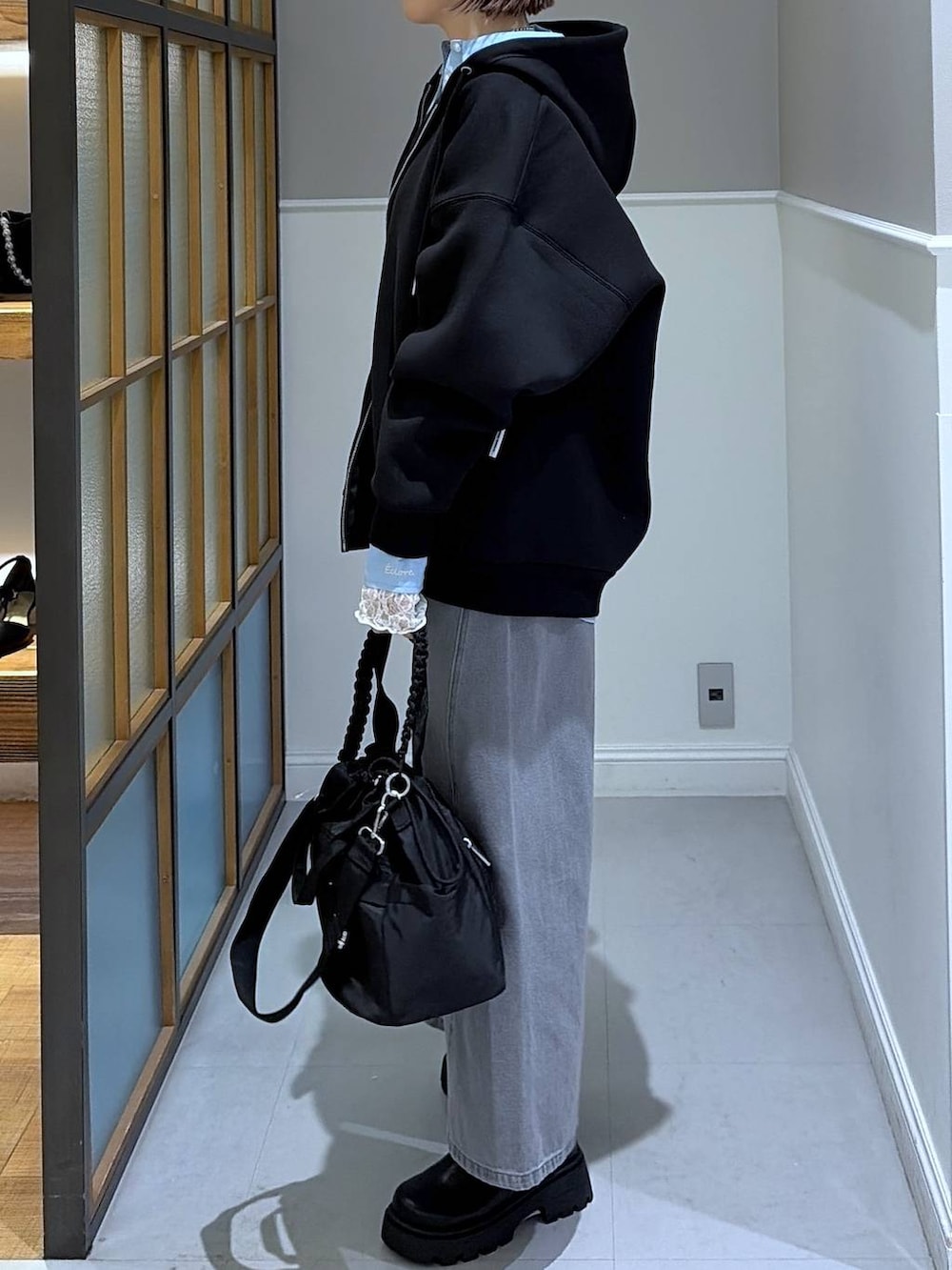 ブラック系のパーカー、グレー系のデニムパンツ、ブルー系のシャツ/ブラウスを着用したレディースの冬コーディネートの3枚目の写真