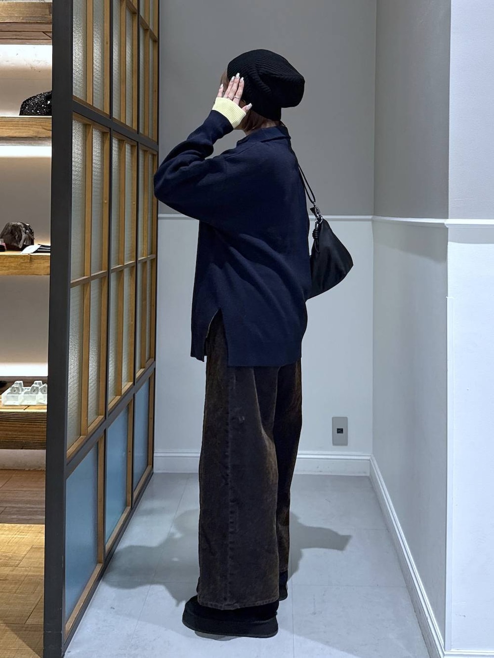 ブラック系のニット/セーター、ブラック系のショルダーバッグ、ブラック系のその他シューズを着用したレディースの冬コーディネートの3枚目の写真