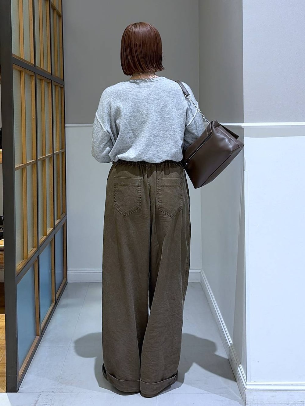 ブラウン系のショルダーバッグ、ブラウン系のその他パンツ、グレー系のニット/セーターを着用したレディースの冬コーディネートの2枚目の写真