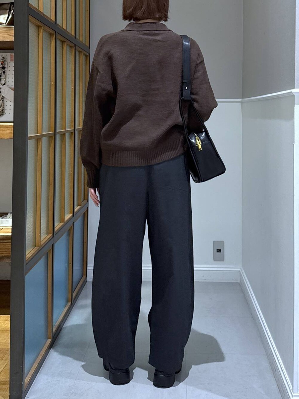 グレー系のその他パンツ、ブラウン系のニット/セーター、ブラック系のブーツを着用したレディースの秋コーディネートの3枚目の写真