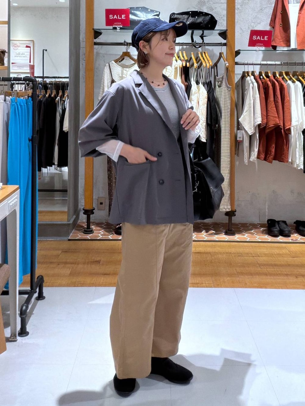 ブラック系のパンプス、ベージュ系のその他パンツ、ブラック系のトートバッグを着用したレディースの夏コーディネートの2枚目の写真
