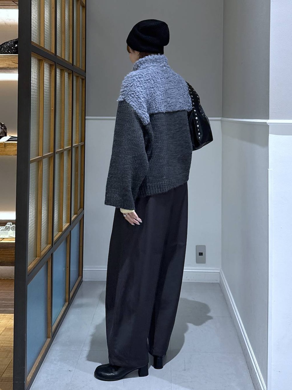 ブラック系のニット/セーター、グレー系のその他パンツ、ブラック系のブーツを着用したレディースの冬コーディネートの3枚目の写真