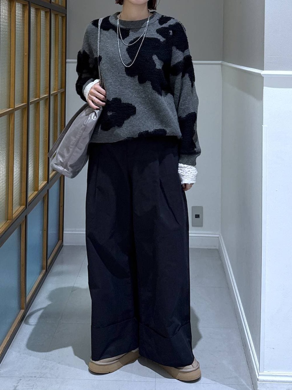 ホワイト系のTシャツ/カットソー、ブラック系のその他パンツ、グレー系のニット/セーターを着用したレディースの冬コーディネートの2枚目の写真