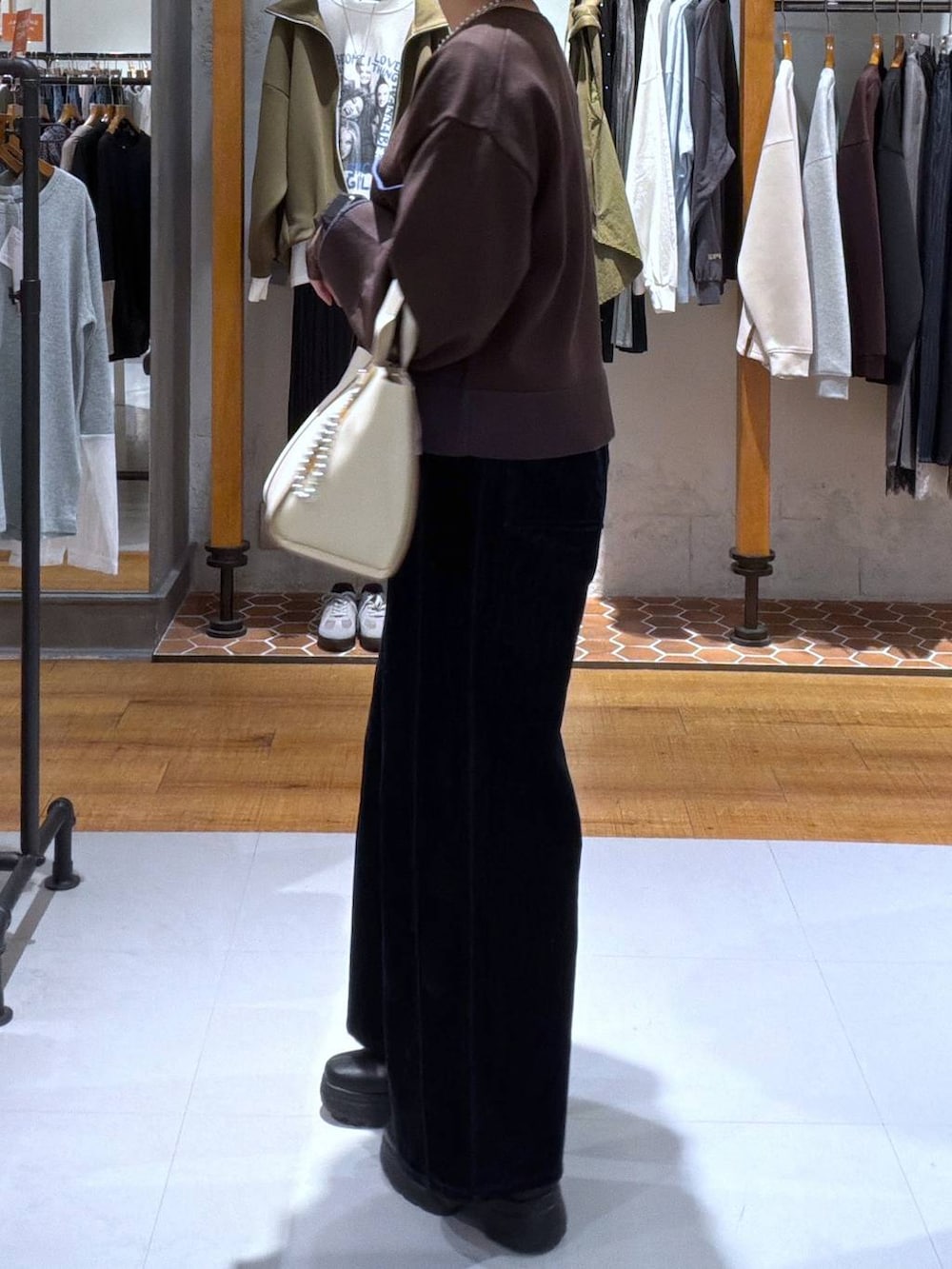 ベージュ系のトートバッグ、ブルー系のその他パンツ、ブラウン系のカーディガン/ボレロを着用したレディースの秋コーディネートの2枚目の写真