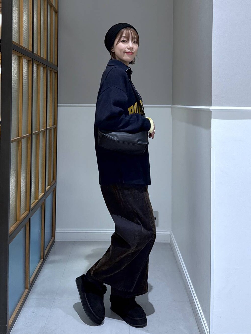 ブラック系のニット/セーター、ブラック系のショルダーバッグ、ブラック系のその他シューズを着用したレディースの冬コーディネートの2枚目の写真