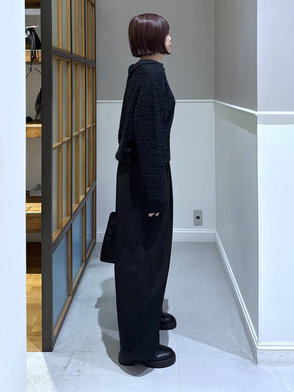 グレー系のその他パンツ、ブラック系のブーツ、ブラック系のトートバッグを着用したレディースの秋コーディネートの2枚目の写真