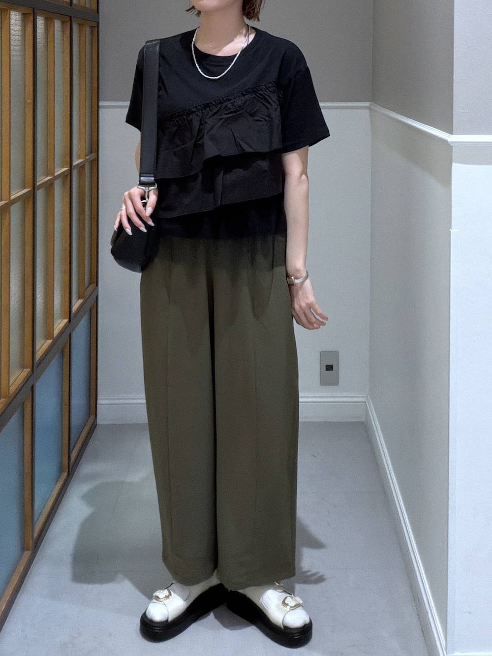 ブラック系のショルダーバッグ、グリーン系のその他パンツ、ホワイト系のサンダルを着用したレディースの春コーディネートの3枚目の写真