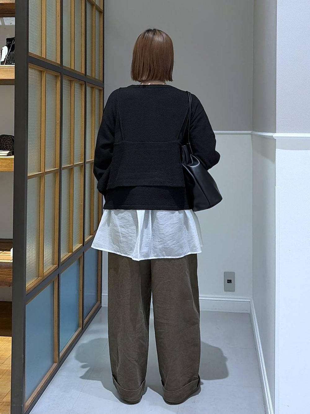 ホワイト系のTシャツ/カットソー、ブラック系のトートバッグ、ブラウン系のその他パンツを着用したレディースの冬コーディネートの3枚目の写真