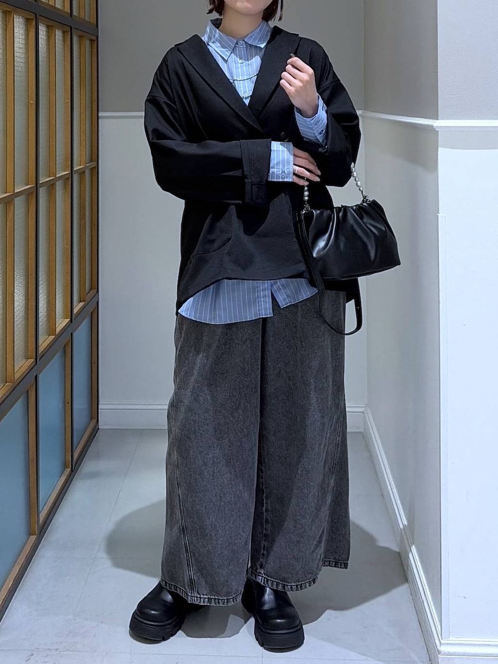 ブラック系のショルダーバッグ、グレー系のデニムパンツ、ブルー系のシャツ/ブラウスを着用したレディースの冬コーディネートの2枚目の写真