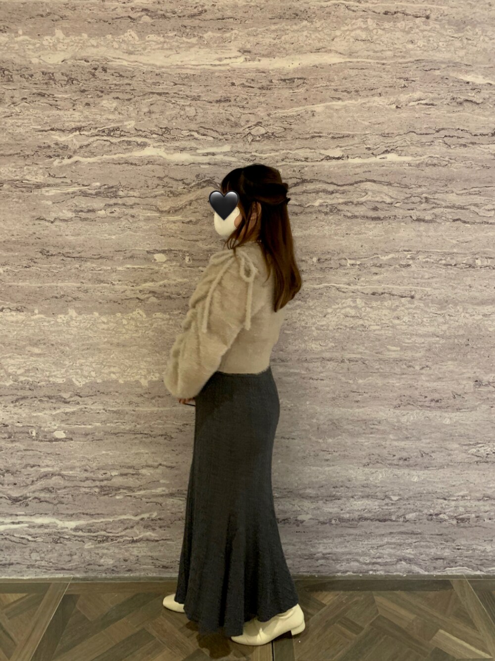 ブラウン系のニット/セーター、グレー系のスカート、ホワイト系のブーツを着用したレディースの冬コーディネートの2枚目の写真